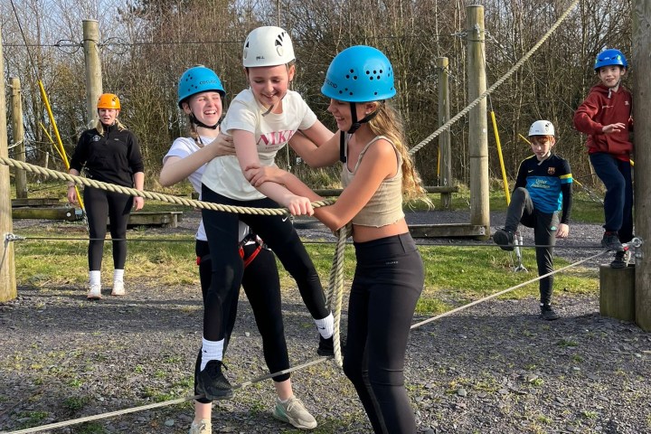 a group of people that are standing in the grass holding a baseball bat