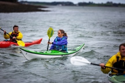 a group of people rowing a boat in the water