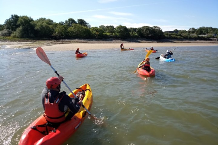 a group of people riding on the back of a boat in the water