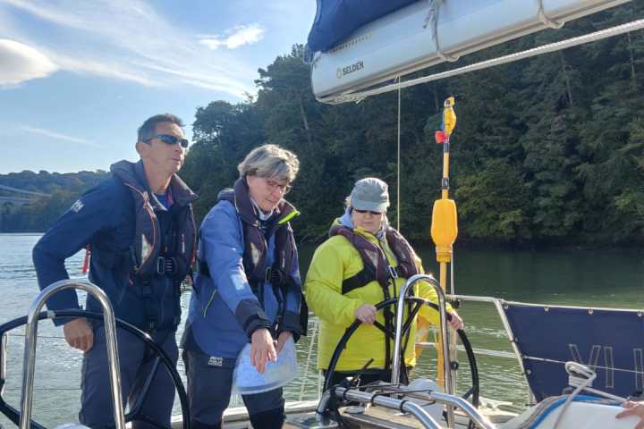 a group of people standing next to a body of water