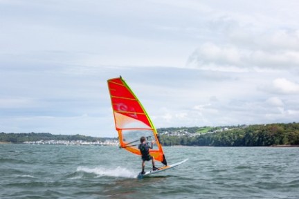 a man flying a kite in a boat on a body of water
