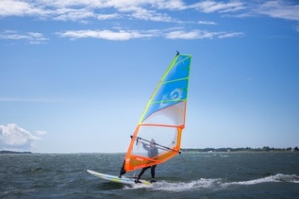 a man riding on the back of a boat in a body of water
