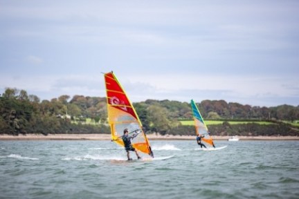 a man flying a kite in a boat on a body of water