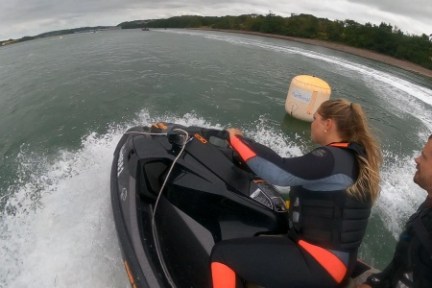 a person wearing a wet suit riding a surfboard in the water