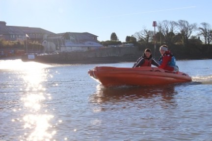 a man riding on the back of a boat in the water