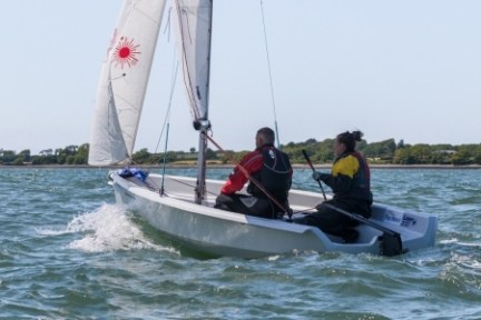 a group of people riding on the back of a boat in the water