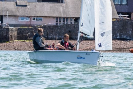 a group of people riding on the back of a boat in the water
