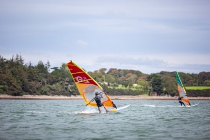 a man flying a kite in a boat on a body of water