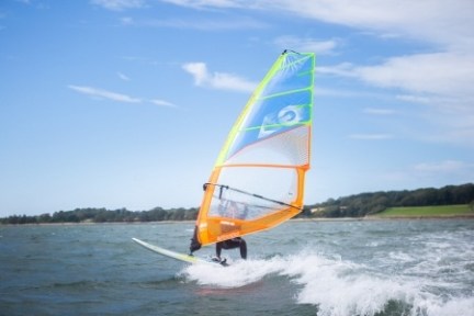 a man flying a kite in a large body of water