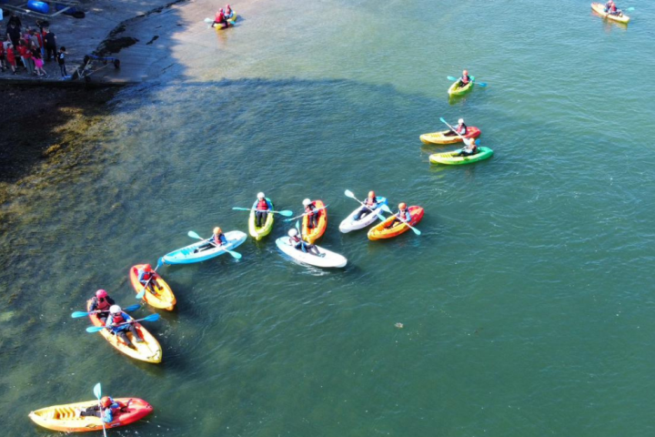 a group of people riding on the back of a boat in the water