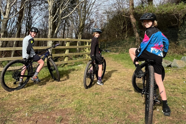 a group of people sitting on a motorcycle in a field