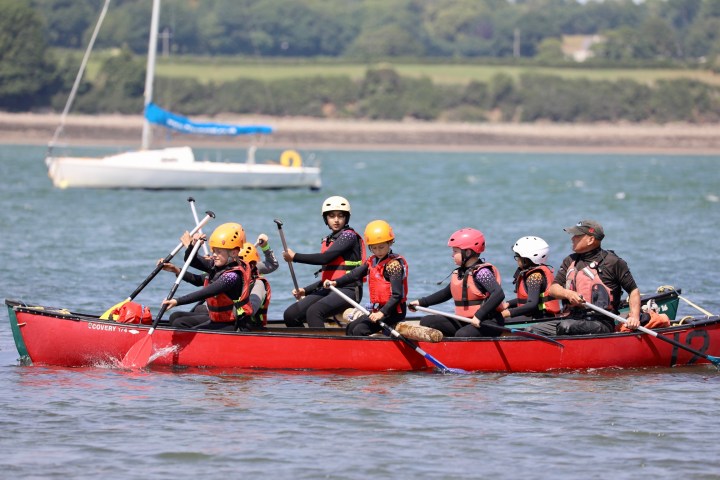 a group of people in a small boat in a body of water