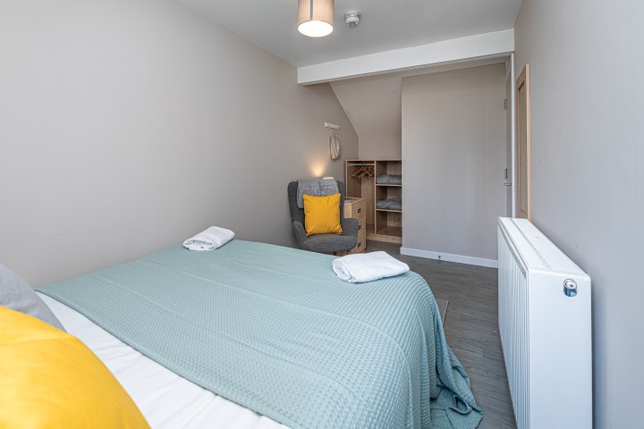 a bedroom with a bed and desk in a room