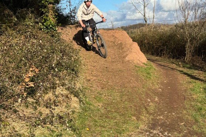 a man riding a bike down a dirt road