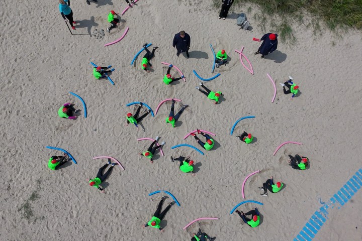 a group of people flying kites on a beach