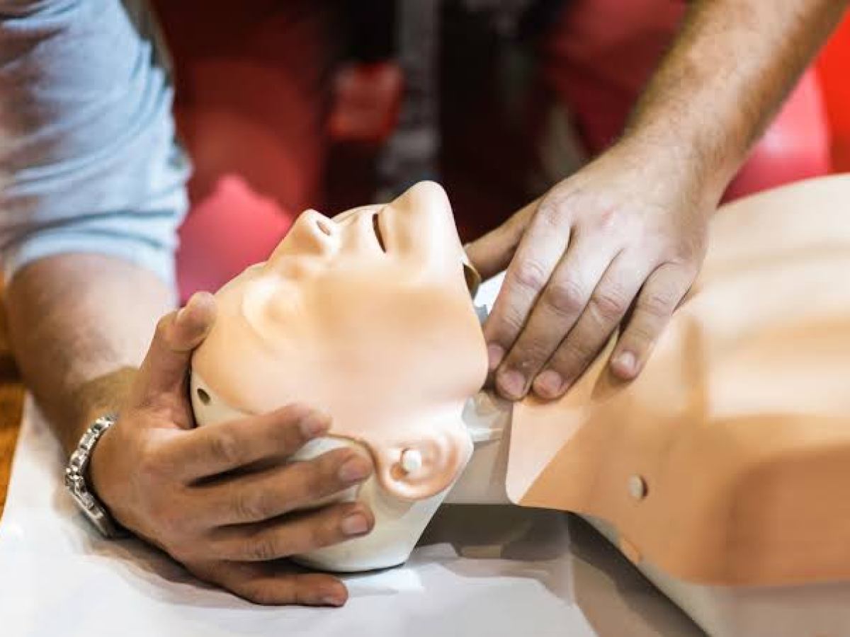 Person performing CPR on a medical mannequin.